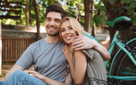 Picture of Happy lovely young couple having rest together and looking at the camera outdoors